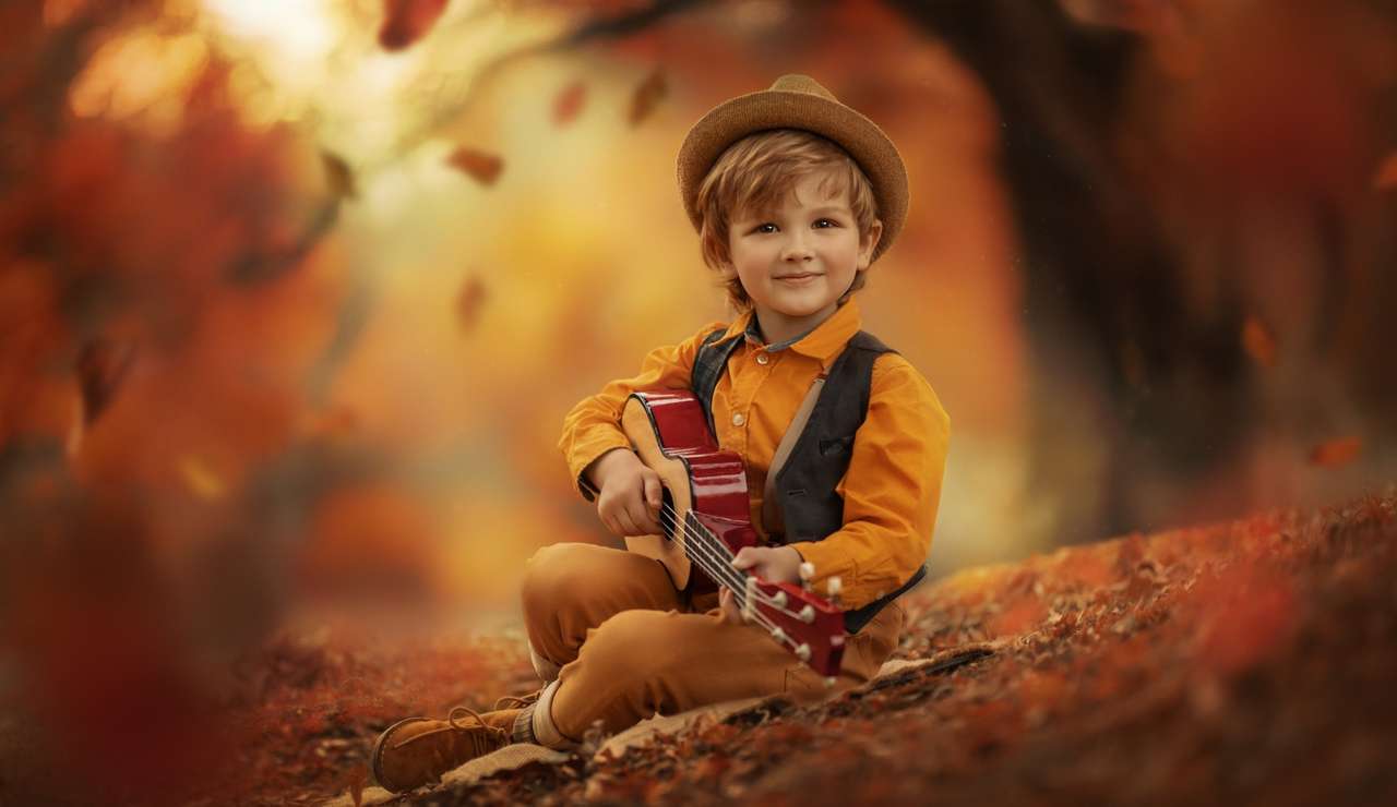 Chłopiec w kapeluszu grający na gitarze puzzle online