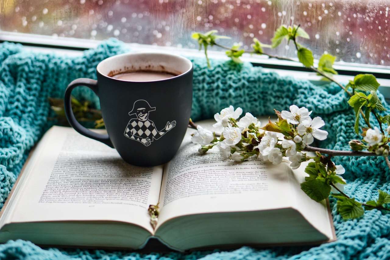 Kubek kawy na otwartej książce w deszczowy dzień puzzle online