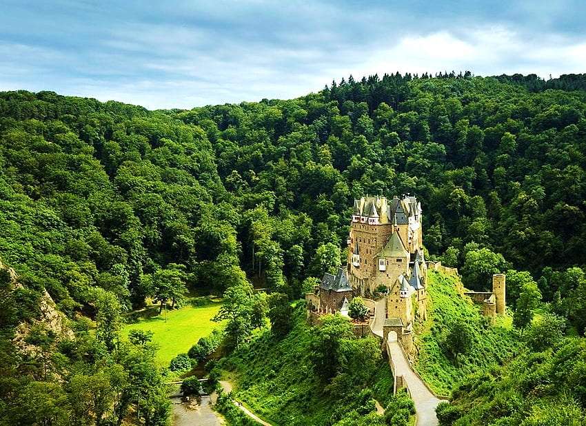 Zamek na szczycie góry wśród zieleni puzzle online