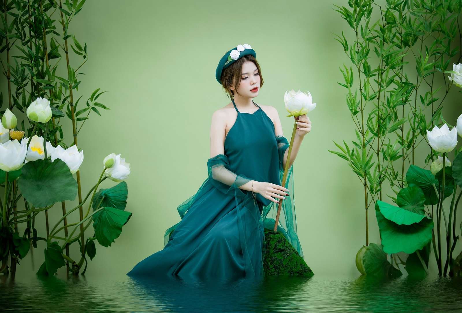 Azjatka w zielonej sukni z kwiatem lotosu w wodzie puzzle online