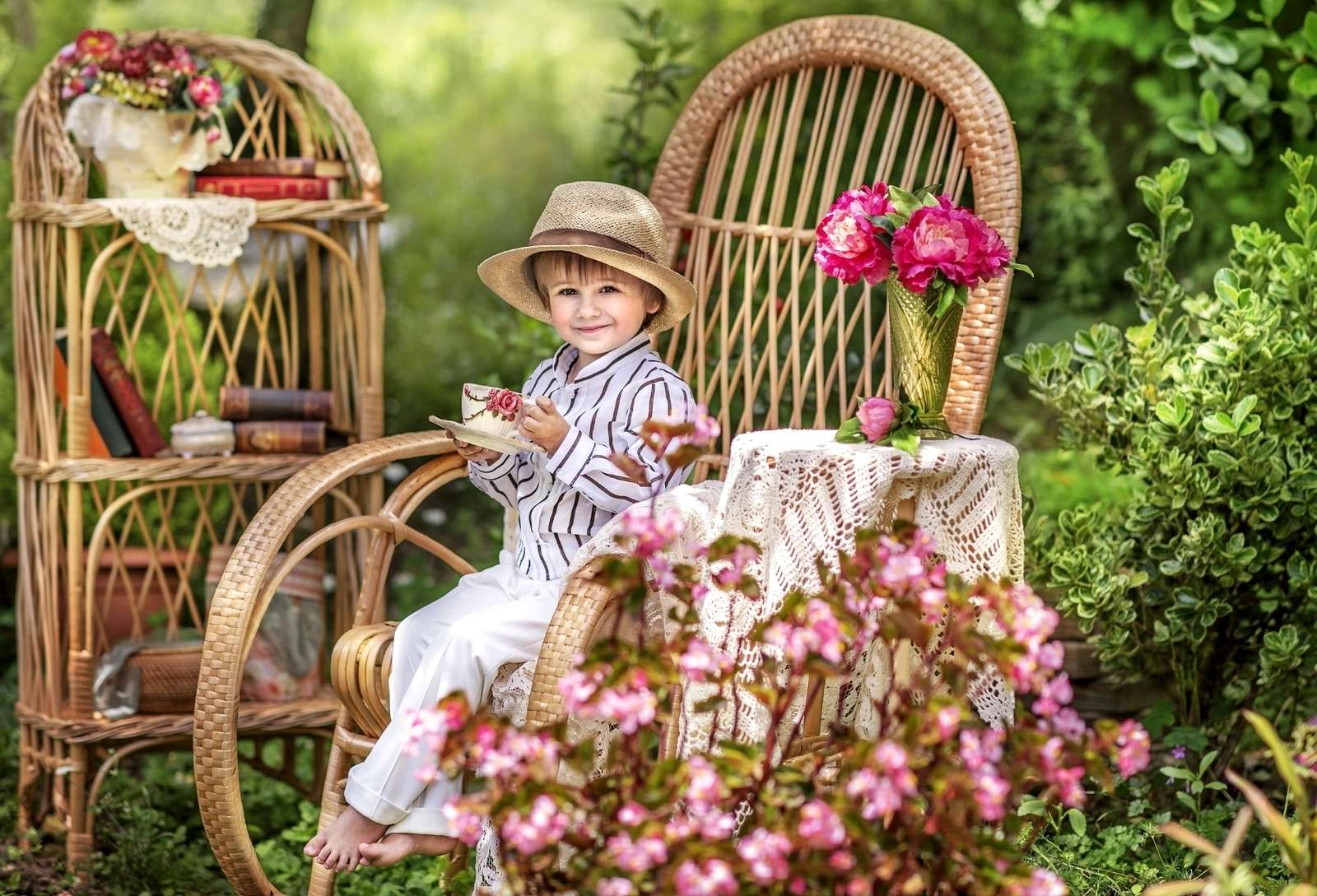 Chłopiec z filiżanką herbaty siedzi w ogrodzie puzzle online