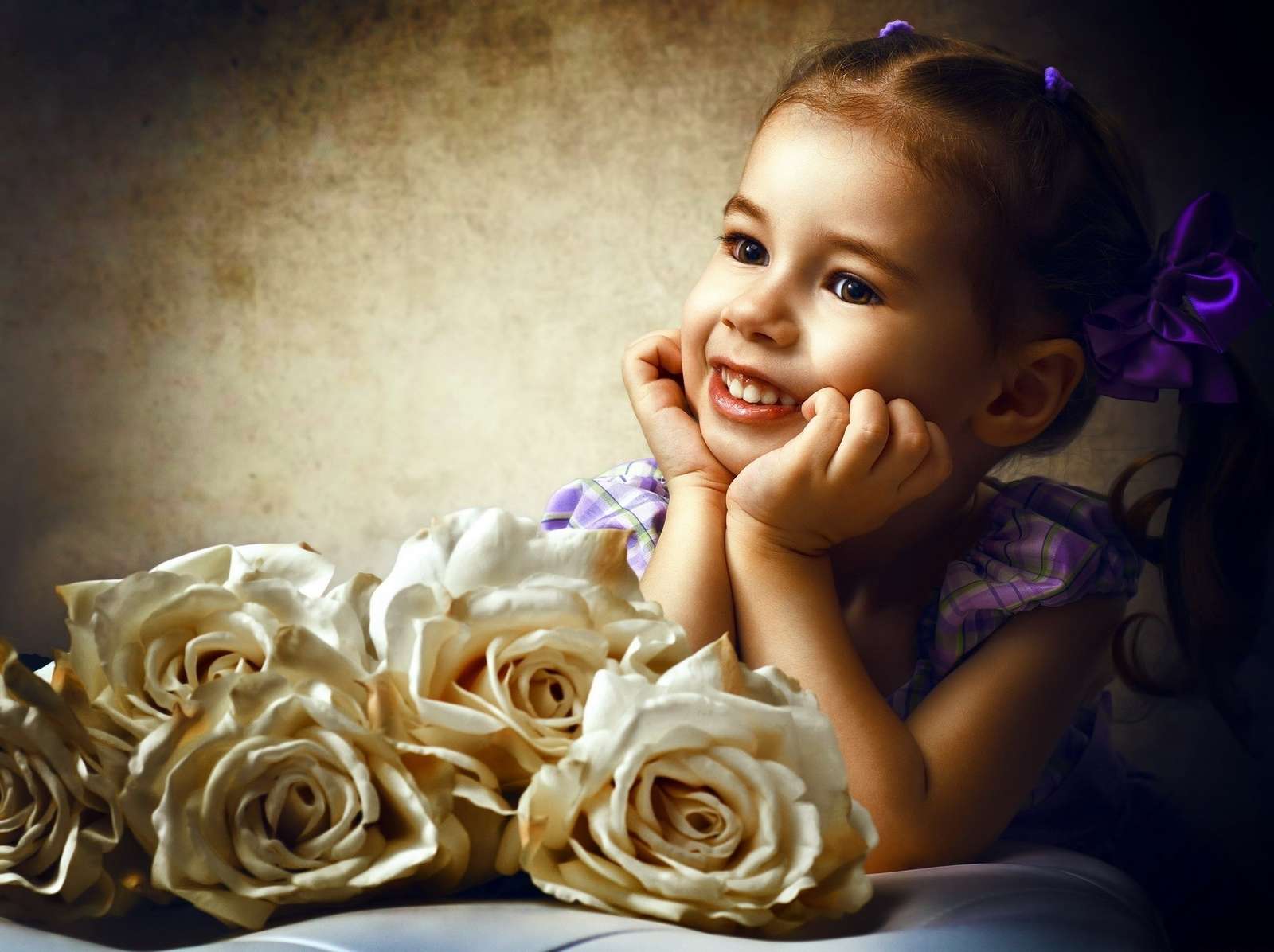 Mała uśmiechnięta dziewczynka obok róż puzzle online
