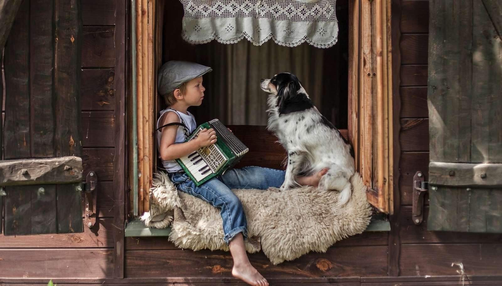 Chłopiec grający na akordeonie na wsi z psem puzzle online